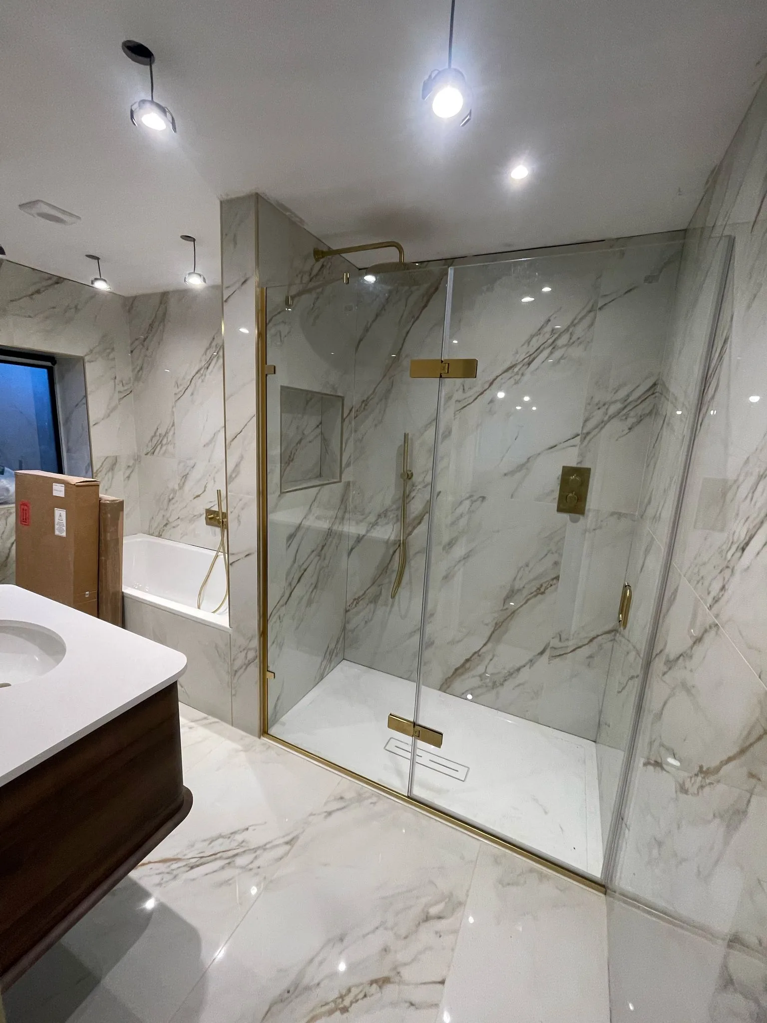 High-spec marble-effect bathroom with brushed gold fittings